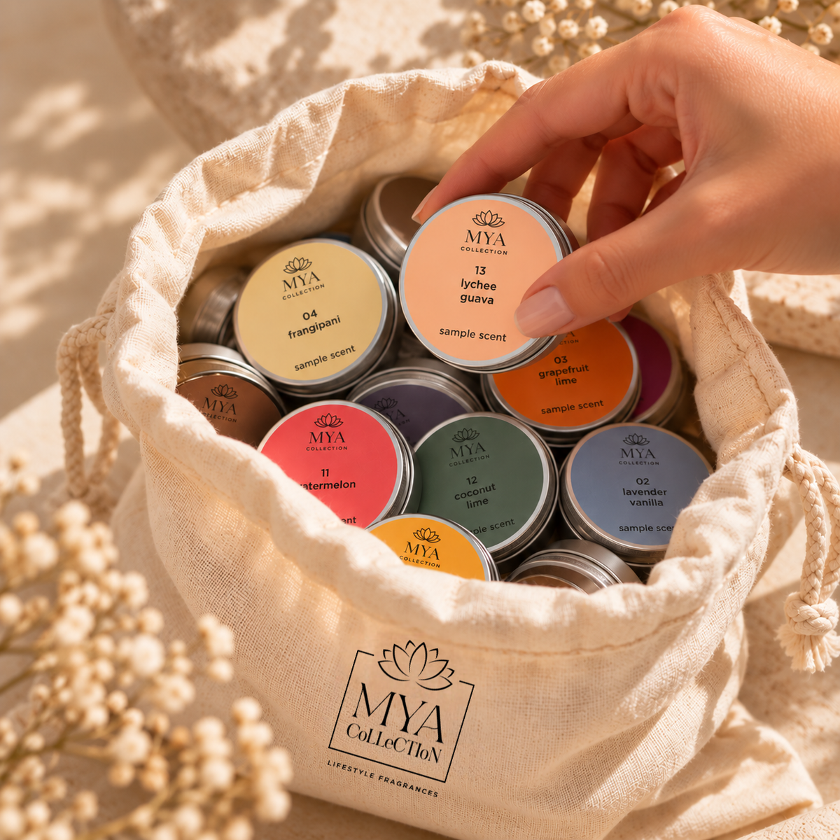 Hand choosing a fragrance sample from the Mya Collection candle scent discovery set
