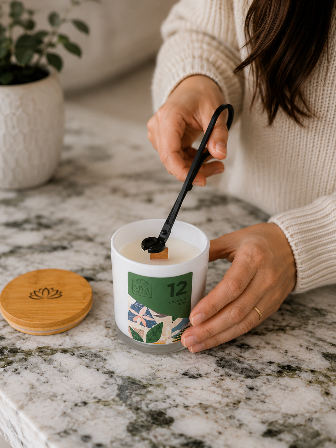 Woman trimming the wooden wick of a Mya Collection candle